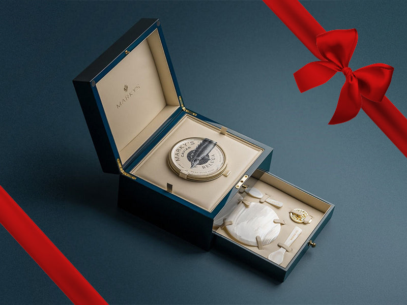 American Beluga 00 Caviar Presentation Box Opened with Mother of Pearl Plate and Spoons and Tin Opener with Gift Bow Graphic on Top Right