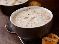 Signature Clam Chowder in bowl with spoon and bread