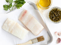 Atlantic Halibut Portions on Baking Sheet with Olive Oil, Capers, Garlic, and Parsley