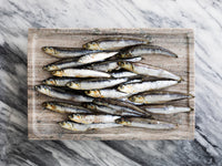 Group of Whole Anchovies on Marble Surface