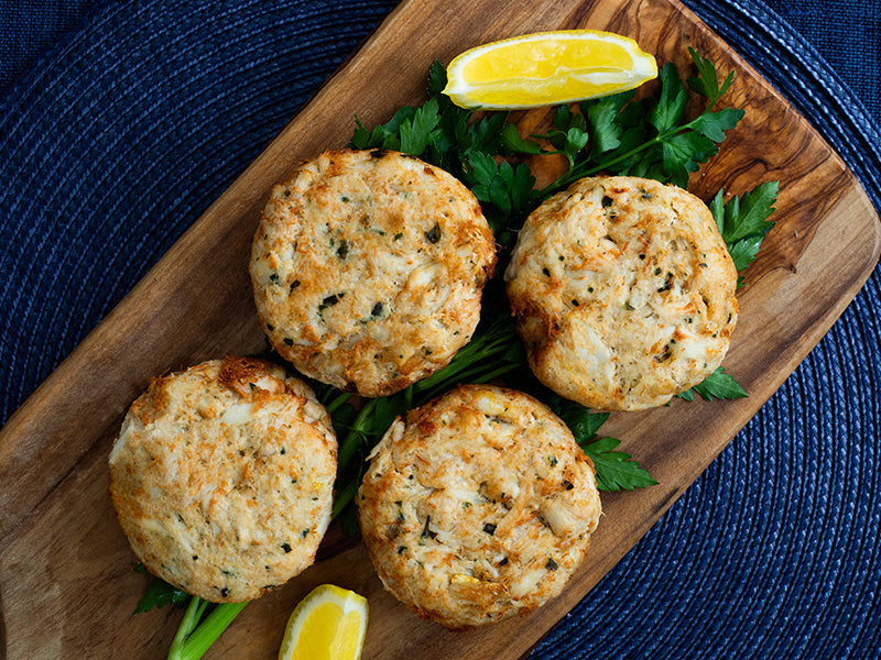 Crab Cakes on Wood Serving Tray with Parsley and Lemon Wedges