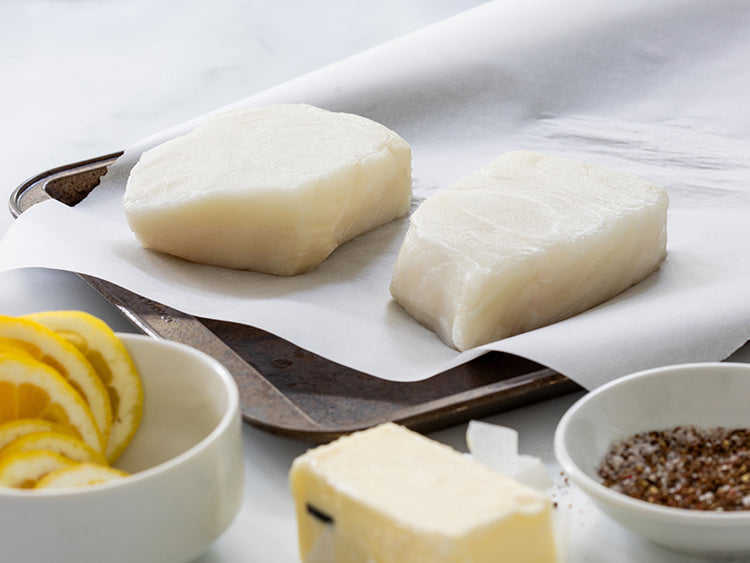 Chilean Sea Bass on Parchment Paper with Butter, Seasoning, and Lemon Slices