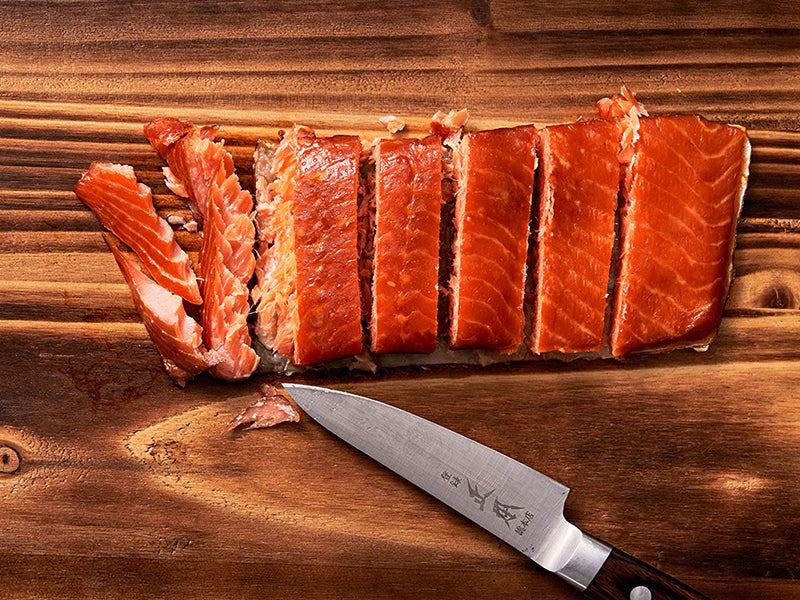 Cut Up Hot Smoked Steelhead Trout Portion on Wood Cutting Board with Knife