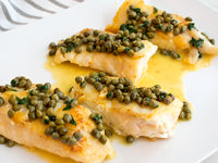 Fulton Fish Market Lemon Caper Sauce on cooked seafood on white plate