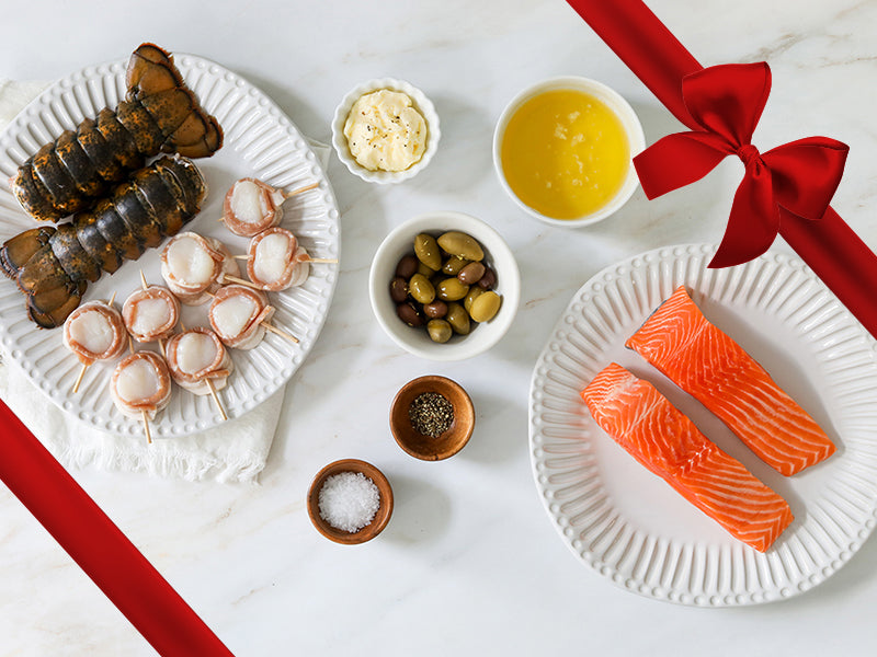 King Salmon Portions, Lobster Tails, and Bacon-Wrapped Scallops on Plates with Capers and Seasonings with Gift Ribbon