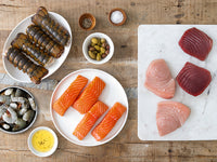 Atlantic Salmon Portions, Ahi Tuna Steaks, Swordfish Steaks, Shrimp, and Lobster Tails on Wood Table