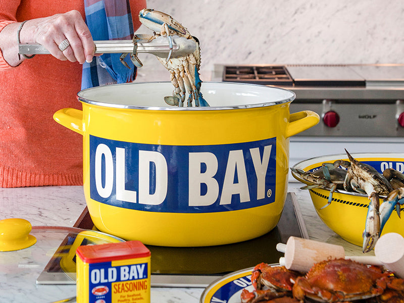 Woman in Kitchen Putting Crabs into Old Bay Stock Pot