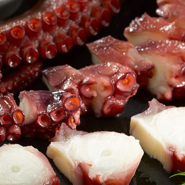 Cooked Octopus Tentacles on Dark Surface