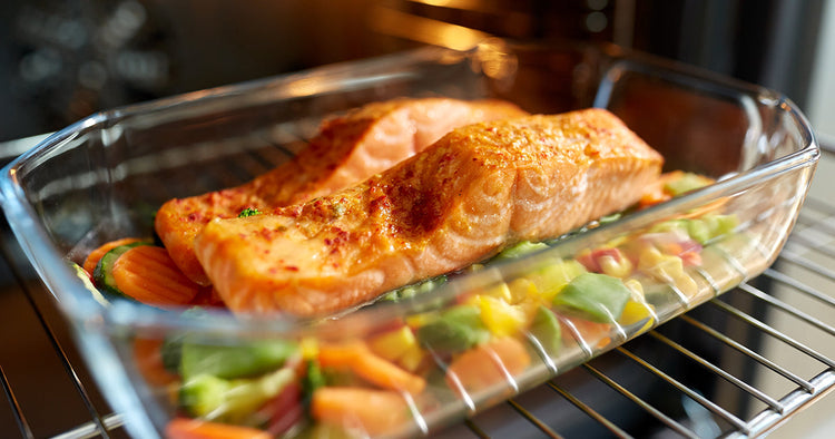 Cooked Salmon in Glass Pan with Veggies Coming Out of the Oven