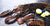 Whole Lobster and Lobster Tails on Dark Surface with Lemon Wedges