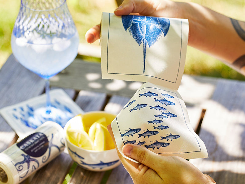 Close Up of Person Tearing off Coastal Cocktail Napkin from Roll