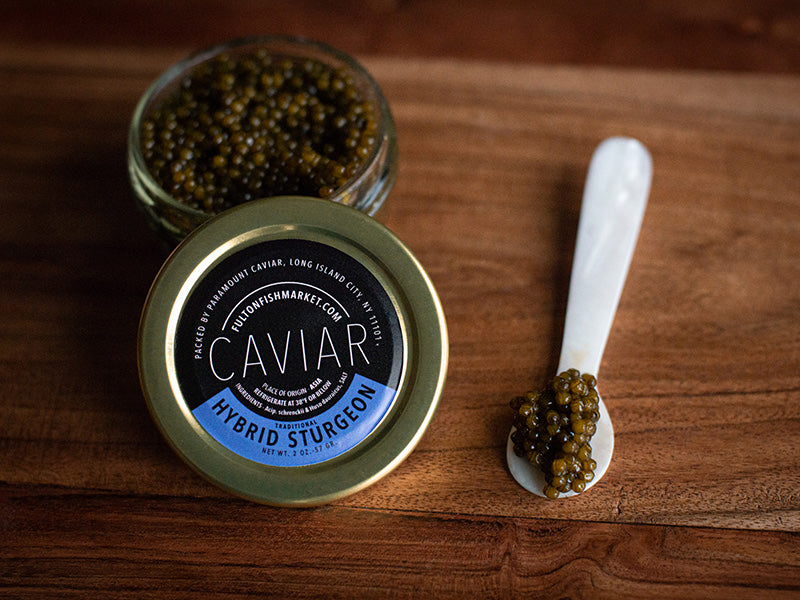 Hybrid Sturgeon Caviar Jar Opened Next to Caviar on Mother of Pearl Spoon on Wooden Surface