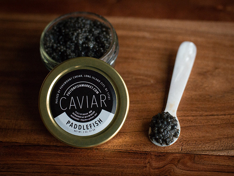 Paddlefish Caviar Jar Opened on Wooden Surface with Caviar on Mother of Pearl Spoon