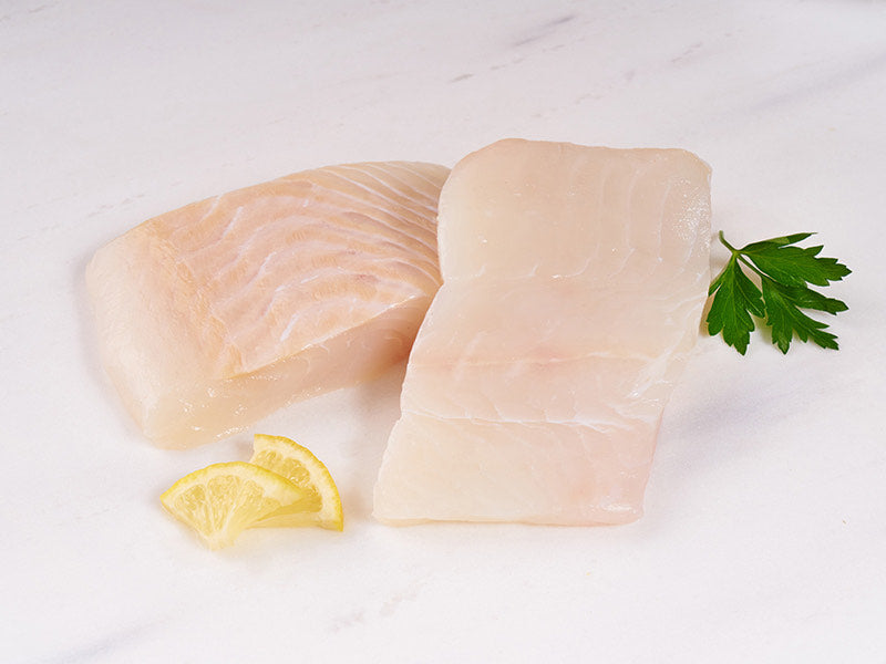 Atlantic Halibut Portions on Light Surface with Lemon