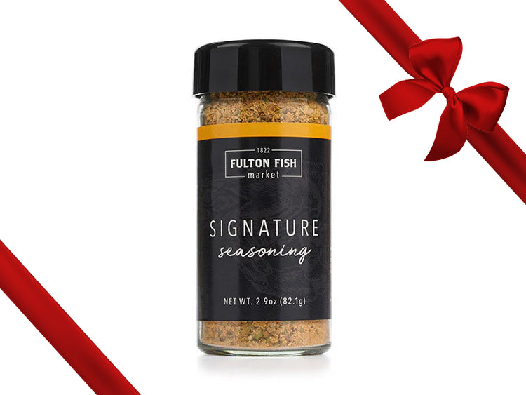 Fulton Fish Market Signature Seasoning Bottle on White Background with Gift Bow Graphic on Top Right