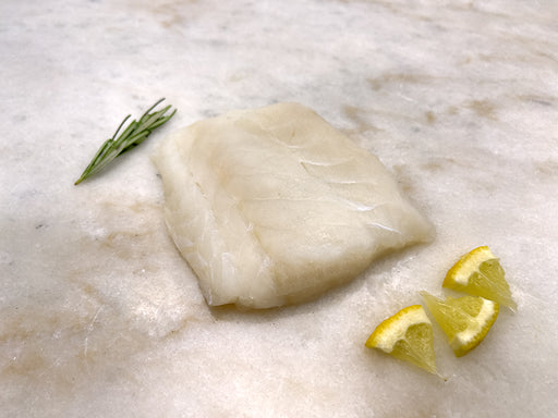 Wild Atlantic Cod Portion with lemon and herb on marble