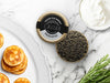 Paddlefish Caviar Tin Opened on Marble Surface with Creme Fraiche and Blinis