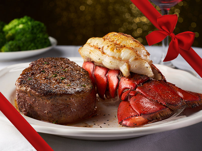 Prepared Surf & Turf Dinner of Steak and Lobster Tails with Gift Bow Graphic on Top Right