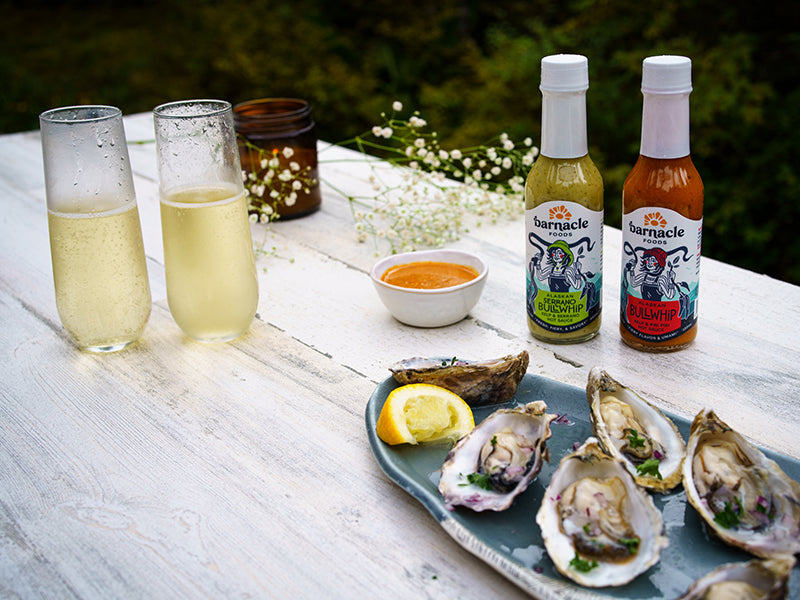 Barnacle Foods Hot Sauce Bottle by Oysters on a Half Shell on Wood Table