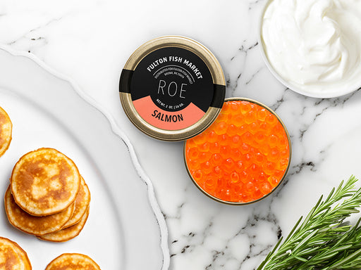 Fulton Fish Market Wild Salmon Roe Tin on Marble Surface with Creme Fraiche and Blinis