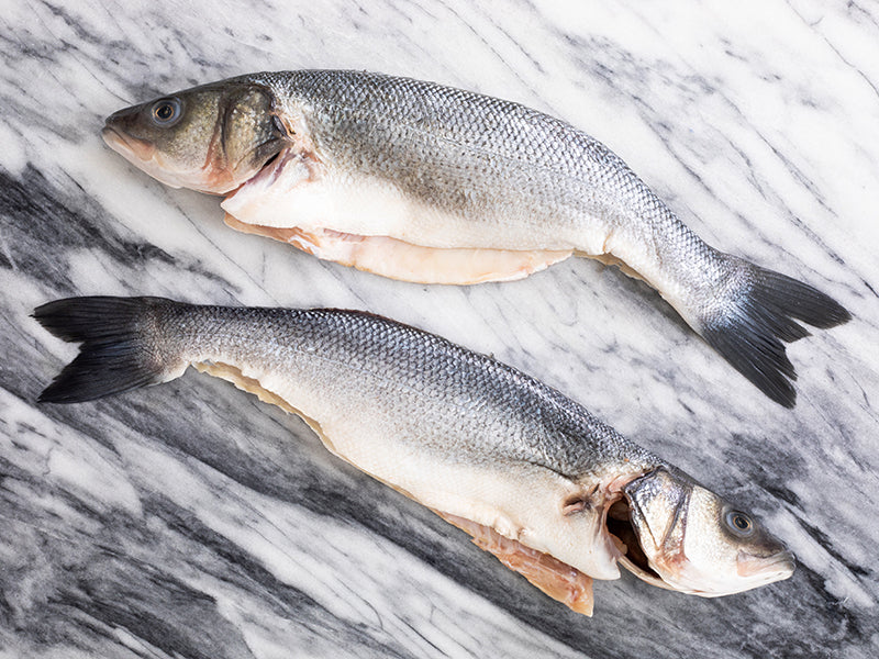 Pair of Butterflied Branzino on Marble Surface