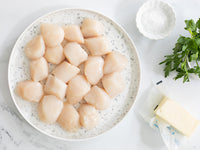 Dry Sea Scallops on Plate Next to Butter, Salt, and Parsley
