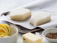 Chilean Sea Bass on Parchment Paper with Butter, Seasoning, and Lemon Slices