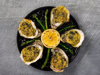 City Pier Oysters Rockefeller on plate with asparagus and lemon