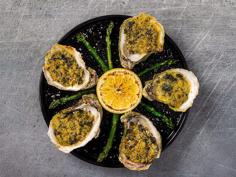 City Pier Oysters Rockefeller on plate with asparagus and lemon