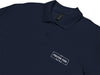 Close Up of Navy Polo Shirt with White Fulton Fish Market Logo on Left Chest on White Background