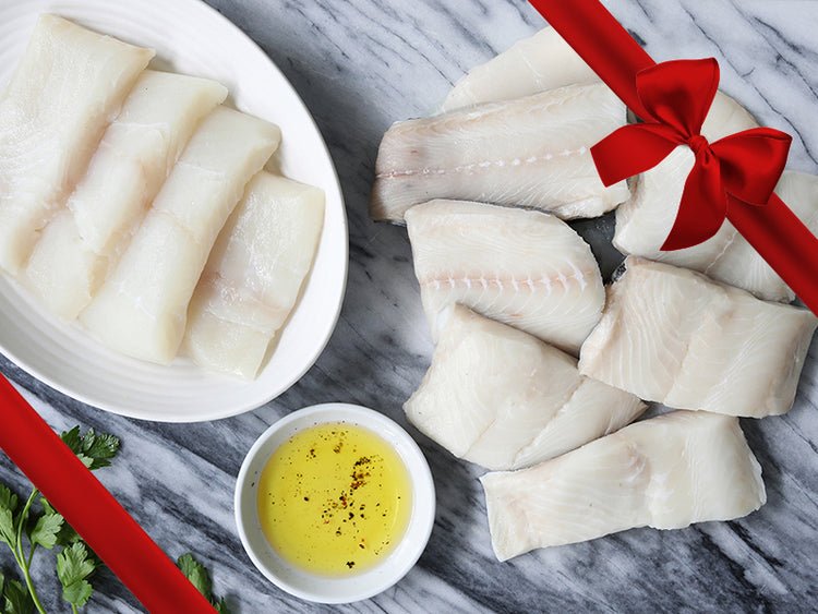 Wild Alaska Black Cod and Pacific Halibut Portions on Marble Surface with Gift Bow Graphic