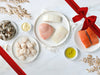 Salmon, Swordfish, Chilean Sea Bass, Halibut, Shrimp, and Scallops on Plates on White Festive Background wtih Gift Ribbon