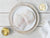 Two Portions of Atlantic Cod on Plate on Light Wood Table with Lemon Wedges and Compound Butter