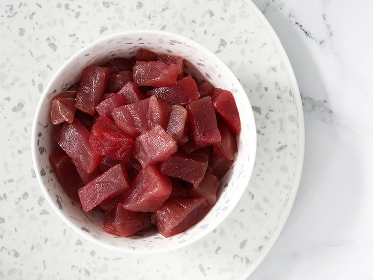 Ahi tuna poke cubes in a bowl on a plate on marble surface