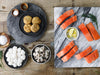 King Salmon Portions, Shrimp, Scallops and Crab Cakes on Plates and Trays with on Wooden Table