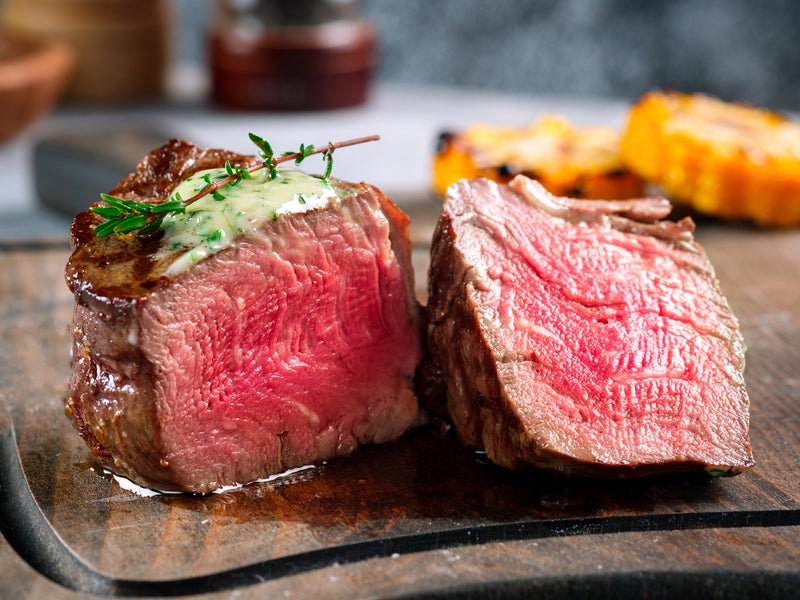 Cooked Pat LaFrieda Prime Filet Mignon Cut in Two Pieces on Wood Cutting Board
