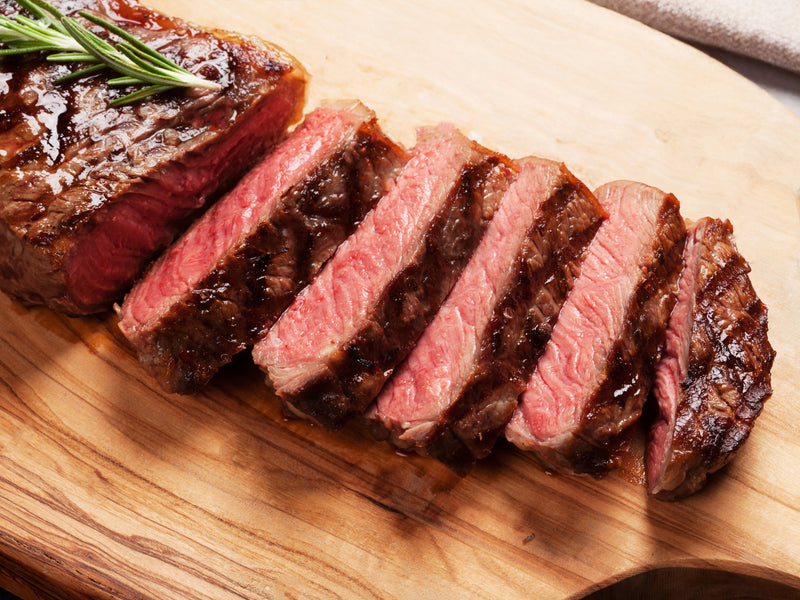 Cooked Pat LaFrieda Prime Boneless New York Strip Sliced on Wood Cutting Board