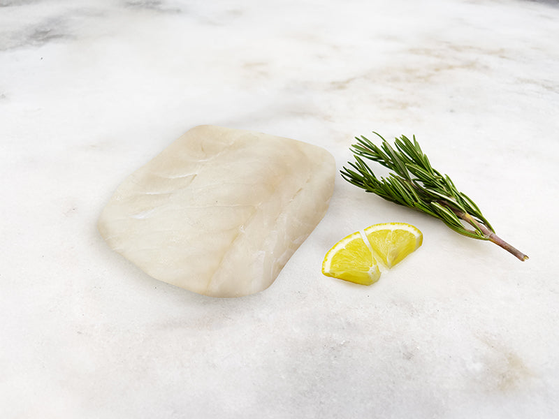 Wild Atlantic Cod Portion on Marble with Lemon and Herbs