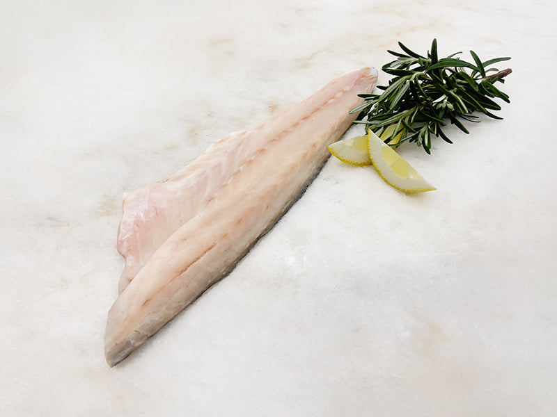 Branzino Fillet on Marble with Lemon and Herbs