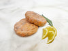 Signature Salmon Burger Patties on Marble with Lemon and Herbs