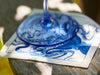 Close Up of Wine Glass On Top of Coastal Cocktail Napkin