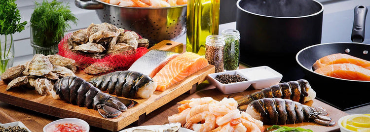 Spread of Lobster Tails, Oysters, Salmon Portions, and Shrimp in Kitchen with Herbs and Spices