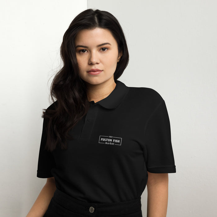Female Model Wearing Black Polo Shirt with White Fulton Fish Market Logo