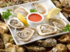 East Coast Oysters on Bed of Ice on White Plate with Lemon, Parsley and Hot Sauce