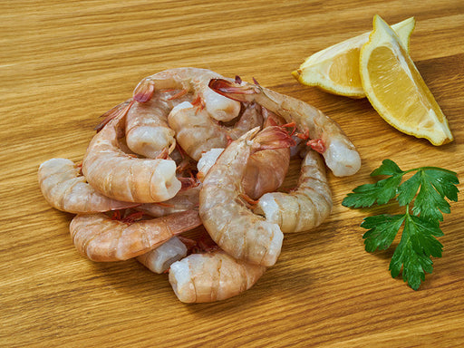 Fresh White Gulf Shrimp on Wooden Surface with Lemons and Parsley
