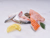 Two Atlantic Salmon Collars on Marble Surface with Lemon and Herbs