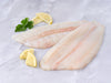 Dover Sole Fillets on Marble Surface with Lemon and Parsley