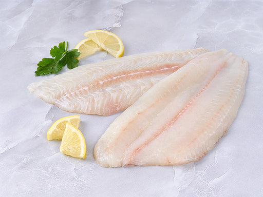 Dover Sole Fillets on Marble Surface with Lemon and Parsley