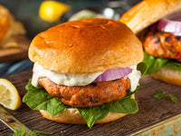 Grilled Signature Salmon Burger with Tartar Sauce, Onions and Spinach on a Bun