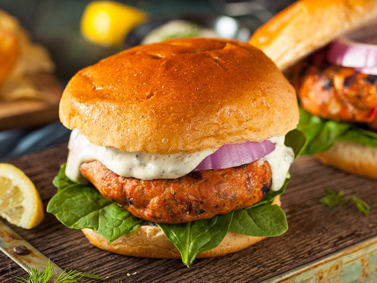 Grilled Signature Salmon Burger with Tartar Sauce, Onions and Spinach on a Bun
